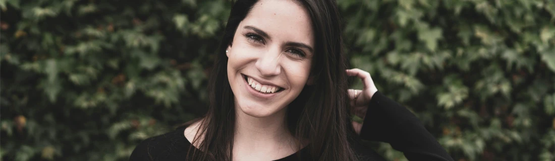 Dentist LaGrange GA Dental Bridge Focused brunette woman with long hair grinning with a huge smile