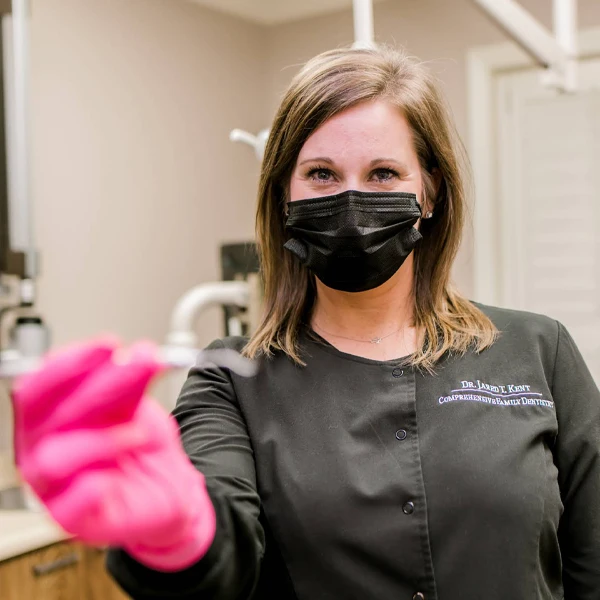 Dentist LaGrange GA Dental Hygenist Patient Point of View a dental assistant is seen in pink gloves and a facemask holding a dental instrument