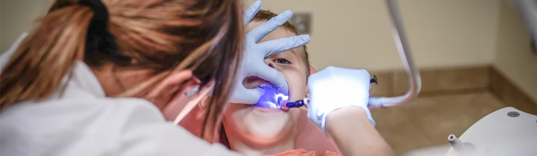 a boy is undergoing emergency dental care for his broken tooth