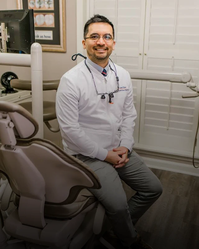 Dr. Jared Kent is seen facing the viewer while sitting on his patient's dental chair