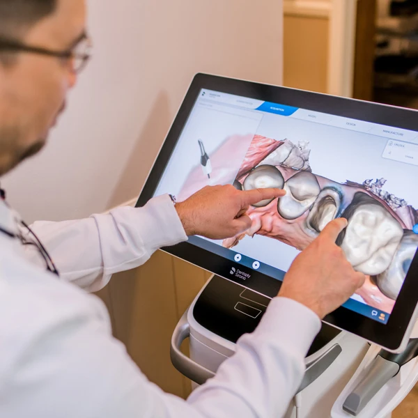 Dr. Jared Kent is seen pointing at a 3D model of a mouth